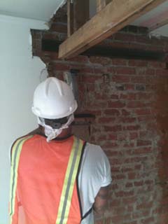 photo of worker removing old wall